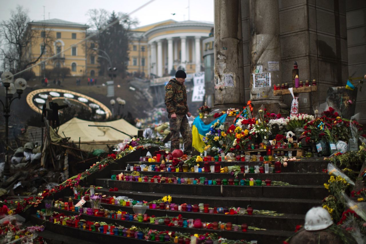 A protester stands at a memorial March 1 for the people killed in clashes at Independence Square.