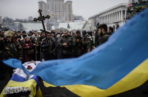 People gather around the coffin of a man who was killed during clashes with riot police in Independence Square.