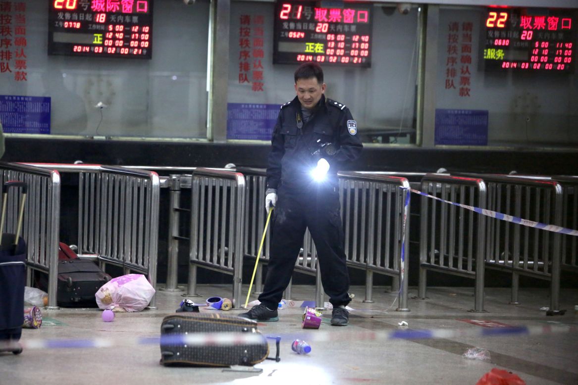 A Chinese police investigator inspects the scene of the attack at the railway station on March 2, 2014.