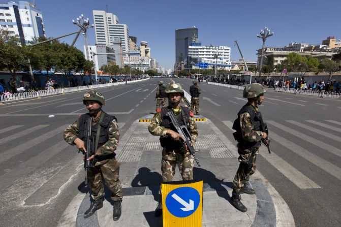 Armed paramilitary policemen guard a crossing in front of Kunming Railway Station in Kunming after a Saturday attack that left dozens dead. 