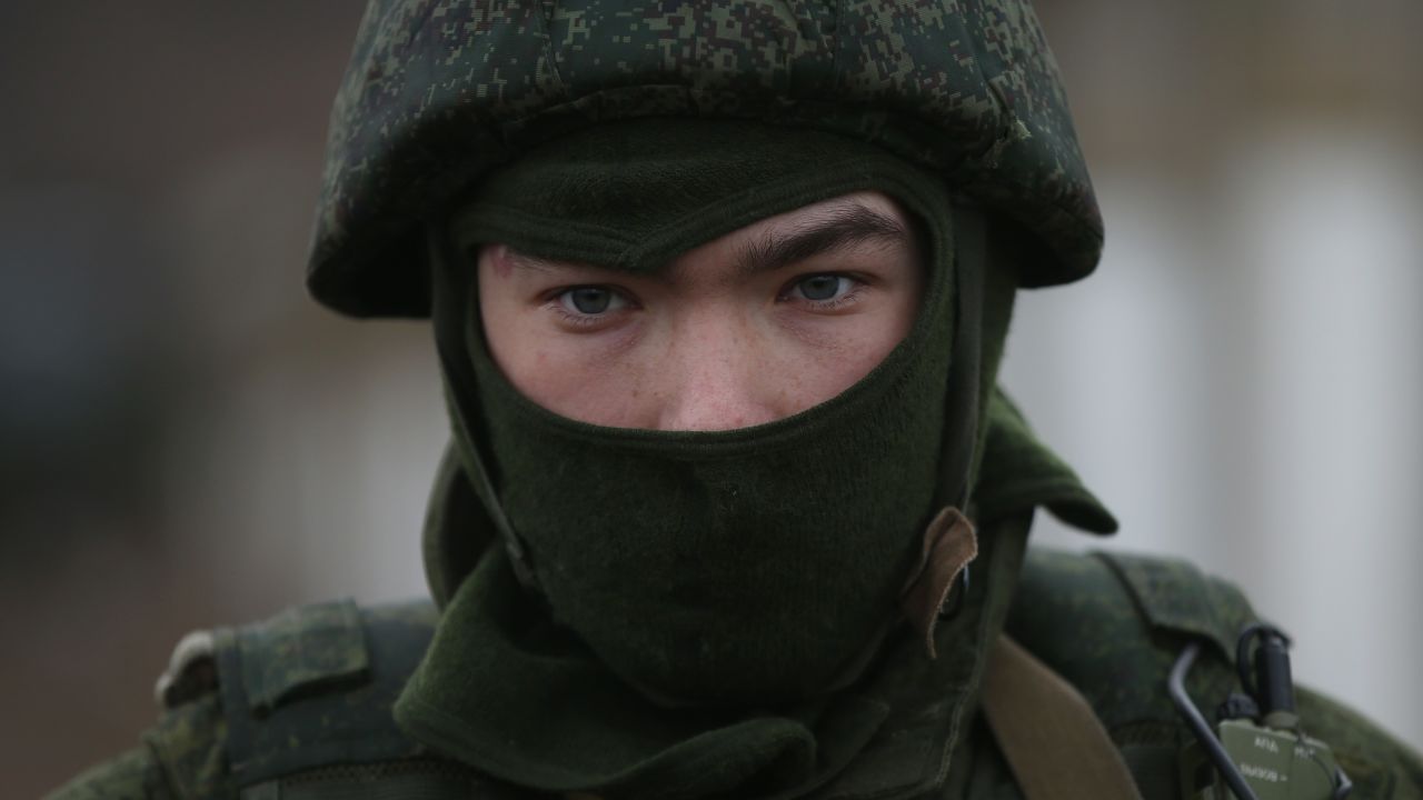 A soldier who was among several hundred that took up positions against a Ukrainian military base stands near the base's periphery in Crimea on March 2, in Perevanie, Ukraine. Several hundred heavily-armed soldiers not displaying any idenifying insignia took up positions outside the base.