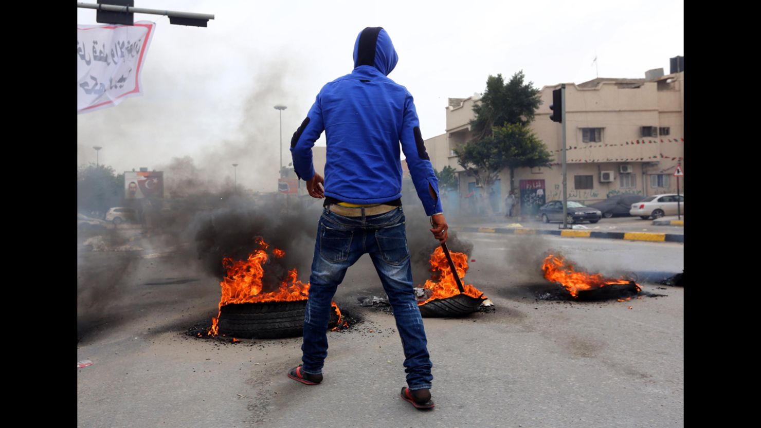 A protester sets tires on fire outside of the Libyan General National Congress in Tripoli on Sunday.