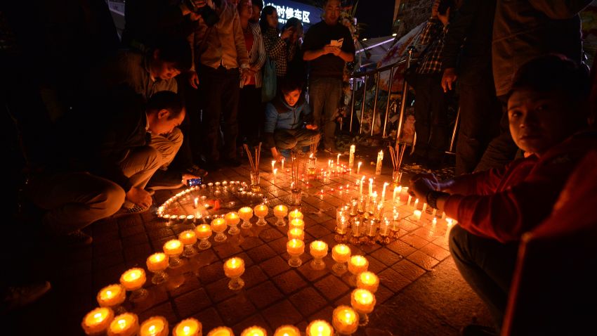 Mourners lights candles at the scene of a terror attack in China in which at least 29 people were killed.