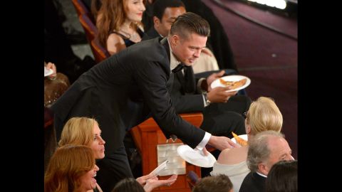 Brad Pitt passes a slice of pizza to Meryl Streep after host Ellen DeGeneres took orders from the crowd.