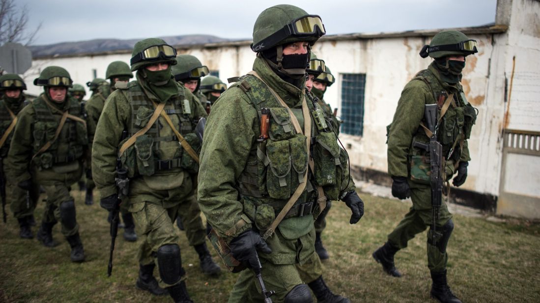 Armed men in military uniform walk outside a Ukrainian military unit near Simferopol on Sunday, March 2. Hundreds of armed men in trucks and armored vehicles surrounded the Ukrainian base Sunday in Crimea, blocking its soldiers from leaving.