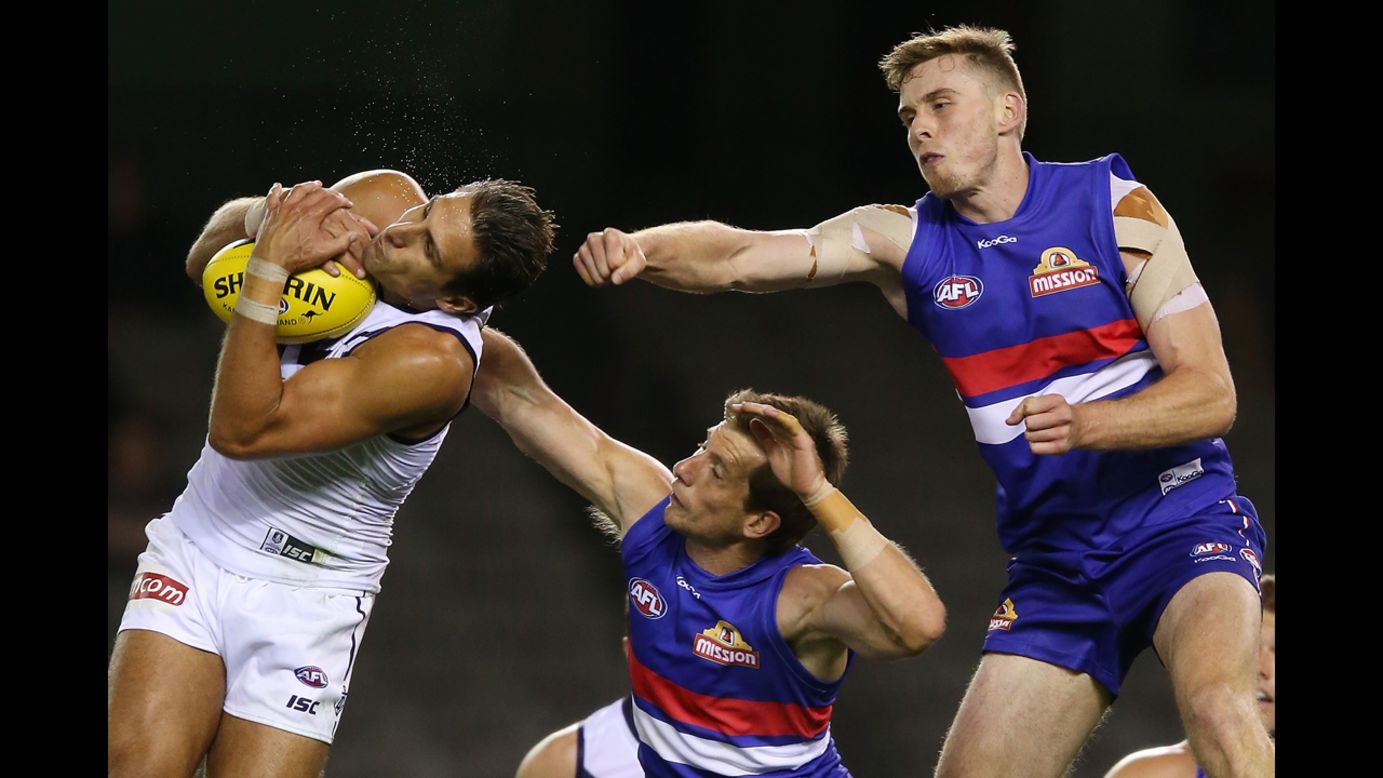 Matthew Pavlich of the Fremantle Dockers marks the ball against Jordan Roughead, right, and Dale Morris of the Western Bulldogs during an Australian rules football match Wednesday, February 26,  in Melbourne.