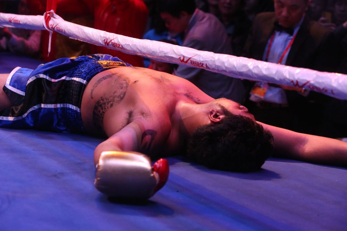 Thai boxer Benz lies on the canvas Friday, February 28, after being knocked out by Chinese boxer Zhang Junlong during a World Boxing Federation match in Qingdao, China.