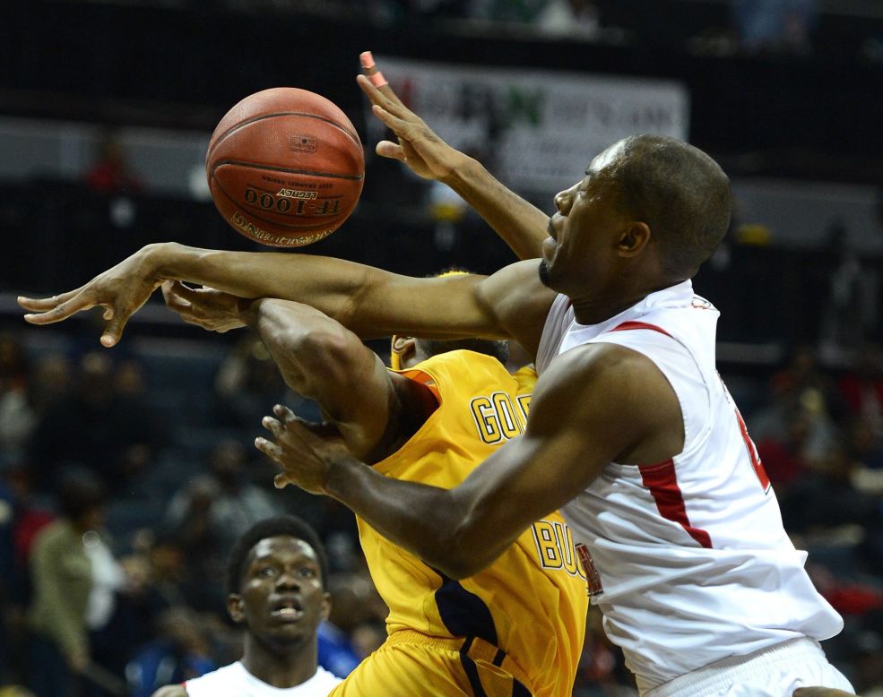 Emilio Parks of Johnson C. Smith University is fouled by Winston-Salem State defender Brian Okam, right, in the CIAA Tournament semifinals at Time Warner Cable Arena in Charlotte, North Carolina, on Friday, February 28.