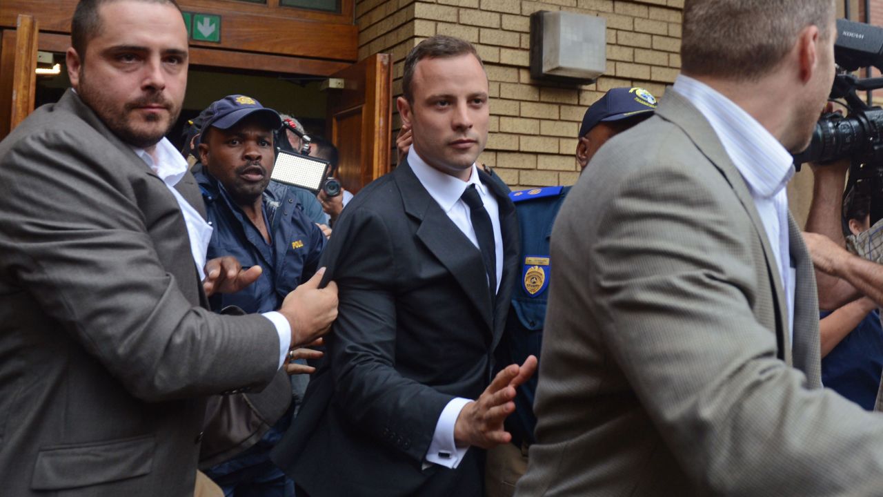 Pistorius is escorted out of the court Monday, March 3, after the first day of his murder trial.