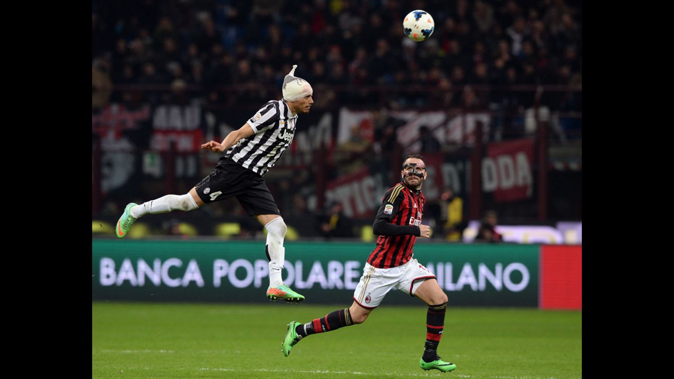Giampaolo Pazzini of AC Milan looks back as Martin Caceres of Juventus leaps for the ball during a Serie A match in Milan, Italy, on Sunday, March 2.
