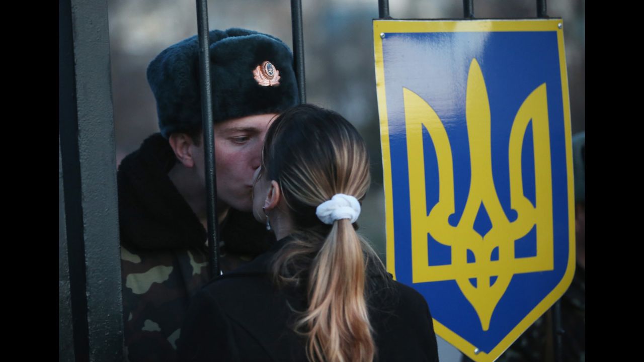 Oleg, a Ukrainian soldier, kisses his girlfriend, Svetlana, through the gates of the Belbek base entrance on March 3. Tensions are high at the base, where Ukrainian soldiers were standing guard inside the building while alleged Russian gunmen were standing guard outside the gates.
