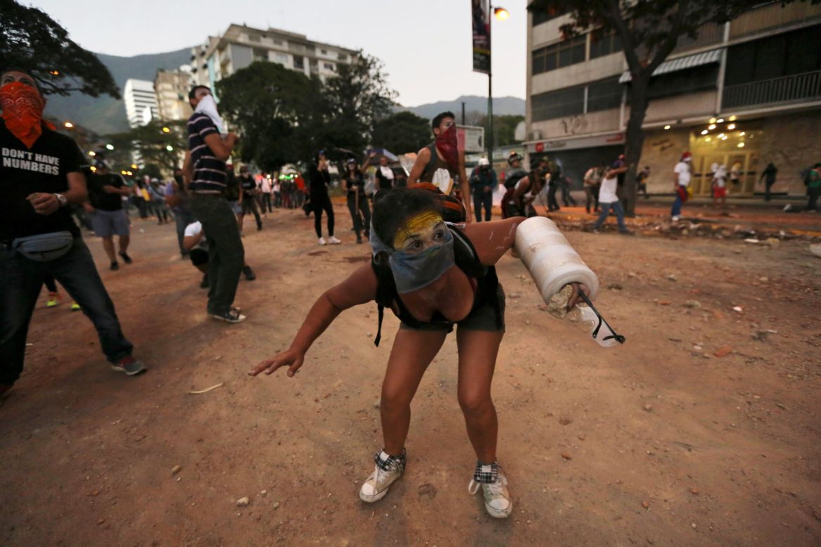 A protester ducks during clashes with police March 3 in Caracas.