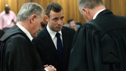 Oscar Pistorius (C) confers with his lawyers on the second day of his murder trial at the North Gauteng High Court in Pretoria, South Africa, on March 4, 2014.