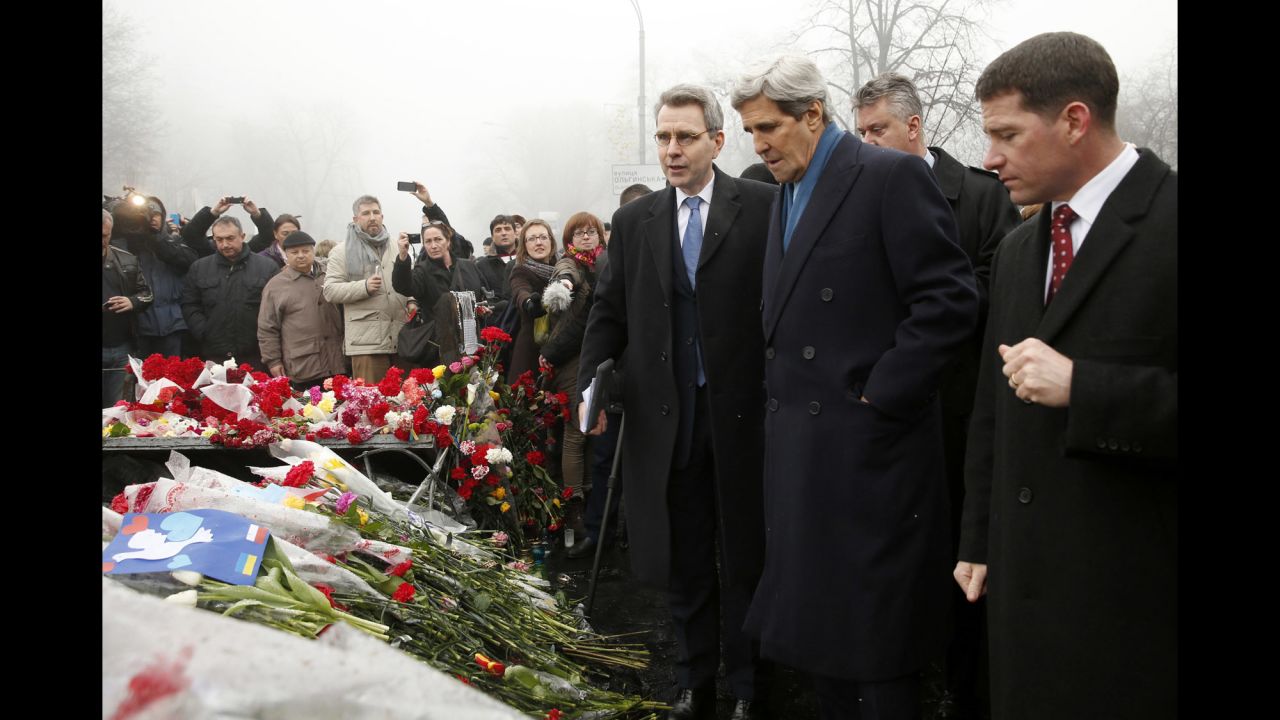 U.S. Secretary of State John Kerry, wearing a blue scarf, visits a shrine March 4 for the people who were killed in February during anti-government protests in Kiev.
