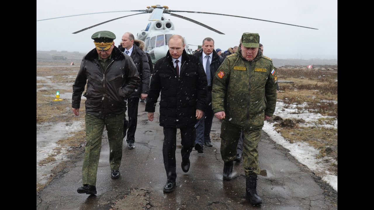 Putin, center, and Defense Minister Sergei Shoigu, left, arrive to watch a March 2014 military exercise at the Kirillovsky firing ground in Russia's Leningrad region.