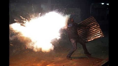 A protester tries to throw a homemade bomb during clashes with police March 3 in Caracas.