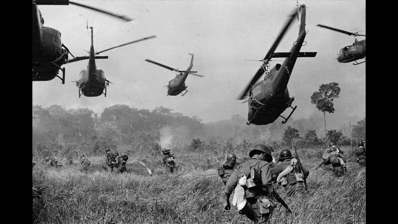 Hovering U.S. Army helicopters pour machine gun fire into the tree line to cover the advance of South Vietnamese ground troops in an attack on a Viet Cong camp northwest of Saigon, near the Cambodian border, in March 1965. The Vietnam War lasted nearly a decade and left more than 58,000 Americans dead.