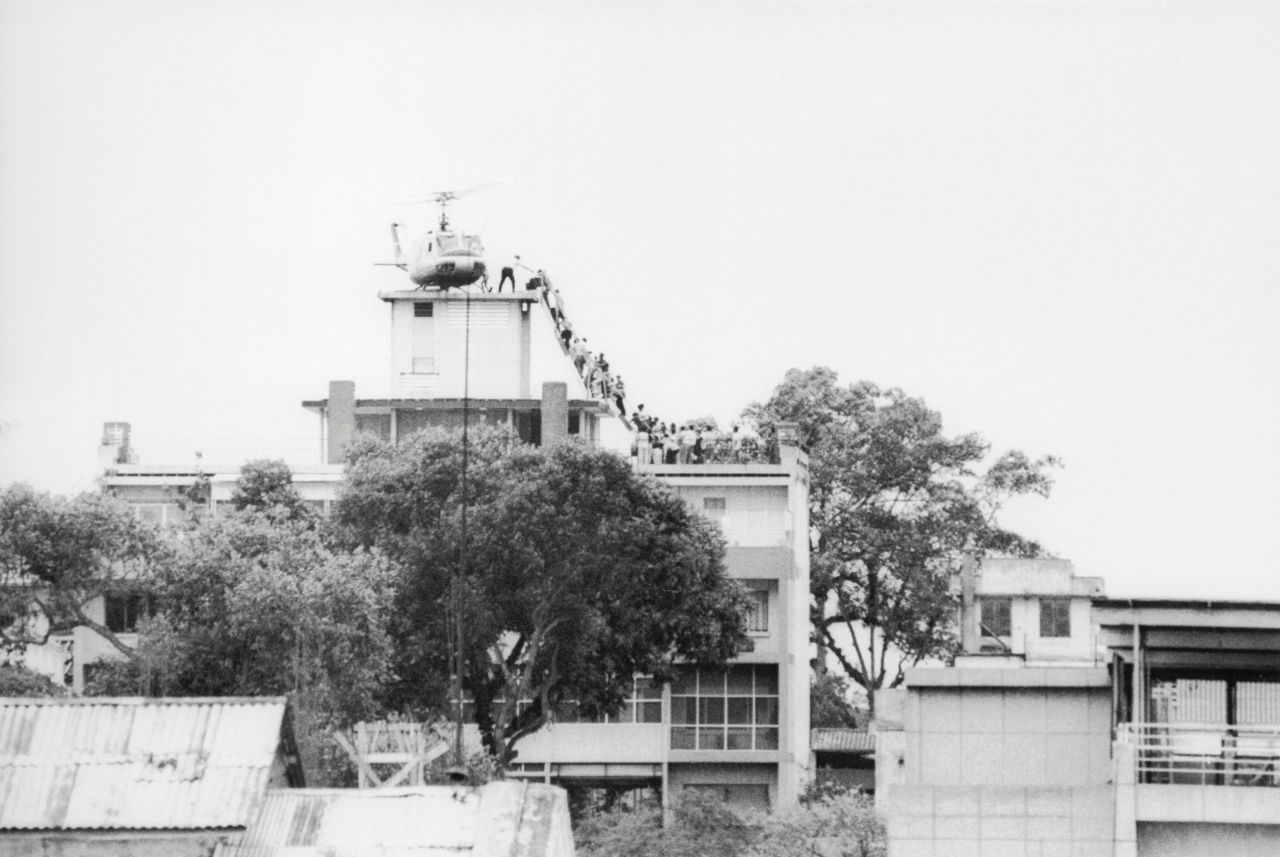 Hubert Van Es, a Dutch photojournalist working at the offices of United Press International, took this photo on April 29, 1975, of a CIA employee helping evacuees onto an Air America helicopter. It became one of the best known images of the U.S. evacuation of Saigon. Van Es never received royalties for the UPI-owned photo. The rights are owned by Bill Gates through his company, Corbis.