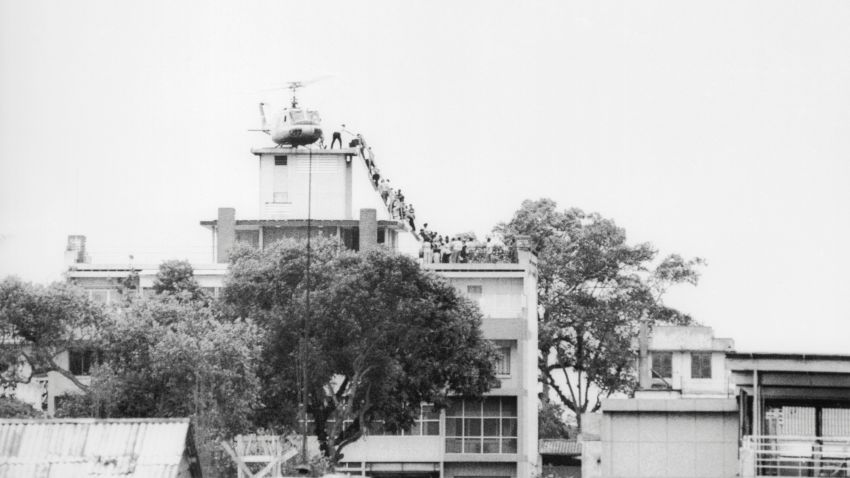 29 Apr 1975 --- A CIA employee (probably O.B. Harnage) helps Vietnamese evacuees onto an Air America helicopter from the top of 22 Gia Long Street, a half mile from the U.S. Embassy. --- Image by © Bettmann/CORBIS