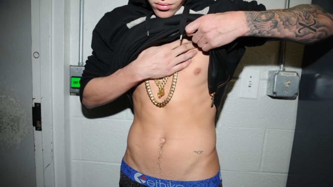 Several photographs of Justin Bieber showing his tattoos to police were released to the media on Tuesday, March 4, 2014. They were taken inside the Miami Beach Police Department's jail, where Bieber was held after his arrest on <a href="http://www.cnn.com/2014/02/26/showbiz/justin-bieber-police-report/index.html">DUI charges</a> on January 23. Here Bieber displays a small bird tattoo.