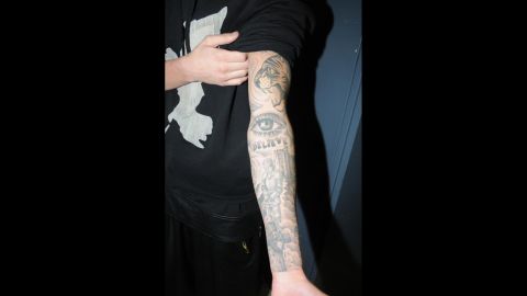One of Bieber's arms is sleeved with multiple tattoos including a tiger head, an eye, the word "believe" and a knight with a castle.