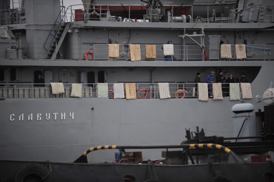 People stand on the Ukrainian Navy ship Slavutych while it's at harbor in Sevastopol on March 4. Mattresses were placed over the side of the ship to hinder any attempted assault.