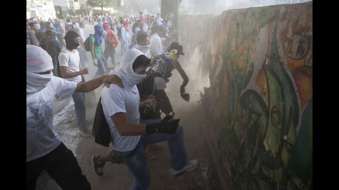 Protesters destroy a wall March 4 to get more rocks to throw at riot police in Caracas.