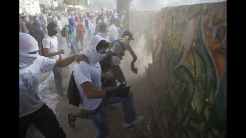 Protesters destroy a wall March 4 to get more rocks to throw at riot police in Caracas.