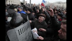 Demonstrators break police ranks smashing their way into the regional administrative building in Donetsk, Ukraine, Wednesday, March 5, 2014. Hundreds of demonstrators waving Russian flags have stormed a government building in Donetsk in the eastern Ukraine. The region is the home area of fugitive Ukrainian President Viktor Yanukovych, who fled the country after massive protests in Kiev. (AP Photo/Sergei Chuzavkov)