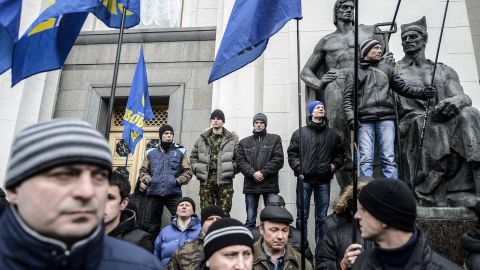 Men carrying far-right Svoboda flags wait in front of the Ukrainian Parliament in Kiev on February 27.
