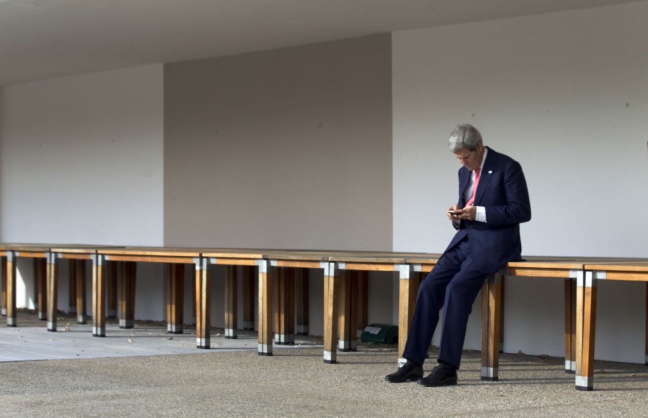 Kerry checks his cell phone in Geneva, Switzerland, prior to a November 2103 meeting with Iran's foreign minister and the European Union's high representative for foreign affairs.