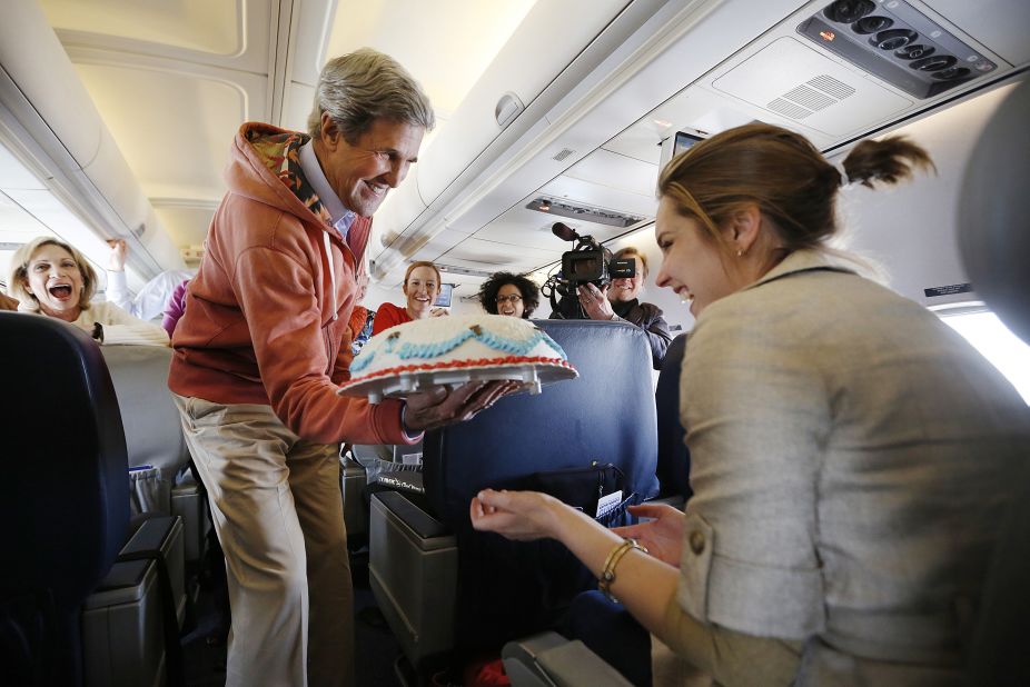 During a flight from Kabul, Afghanistan, to Paris in March 2013, Kerry presents a birthday cake to traveling CBS correspondent Margaret Brennan. 