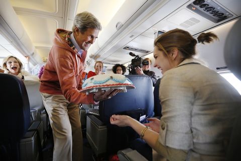 During a flight from Kabul, Afghanistan, to Paris in March 2013, Kerry presents a birthday cake to traveling CBS correspondent Margaret Brennan. 