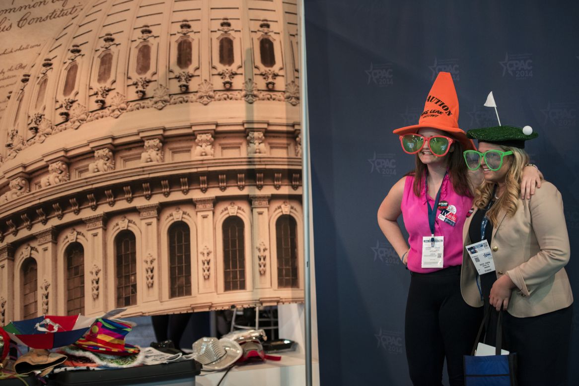 Two women pose is a photo booth with a picture of the U.S. Capitol in the background at CPAC on Thursday.