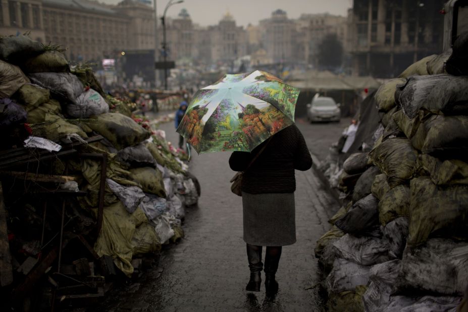 A woman walks past barricades March 6 that were set up by anti-government protesters in Kiev's Independence Square.