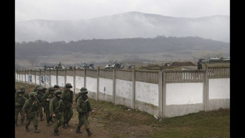 Armed men believed to be Russian military march in a village outside Simferopol on Friday, March 7.