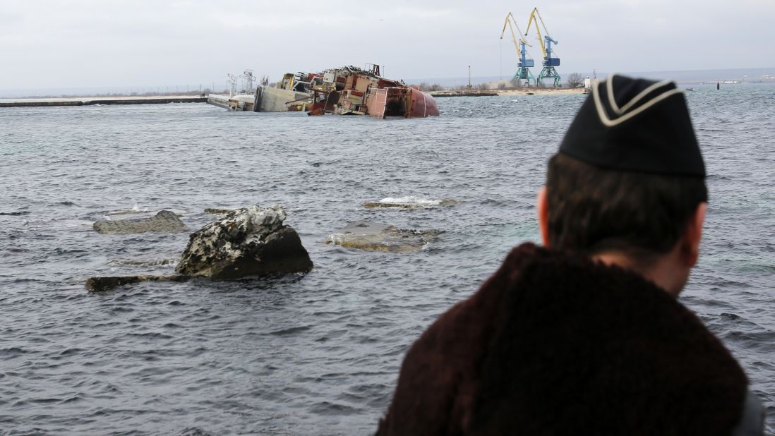 A Ukrainian navy officer looks at the scuttled, decommissioned Russian vessel Ochakov from the Black Sea shore outside the town of Myrnyi, Ukraine, on March 6. Russian naval personnel scuttled the ship, blockading access for five Ukrainian naval vessels.