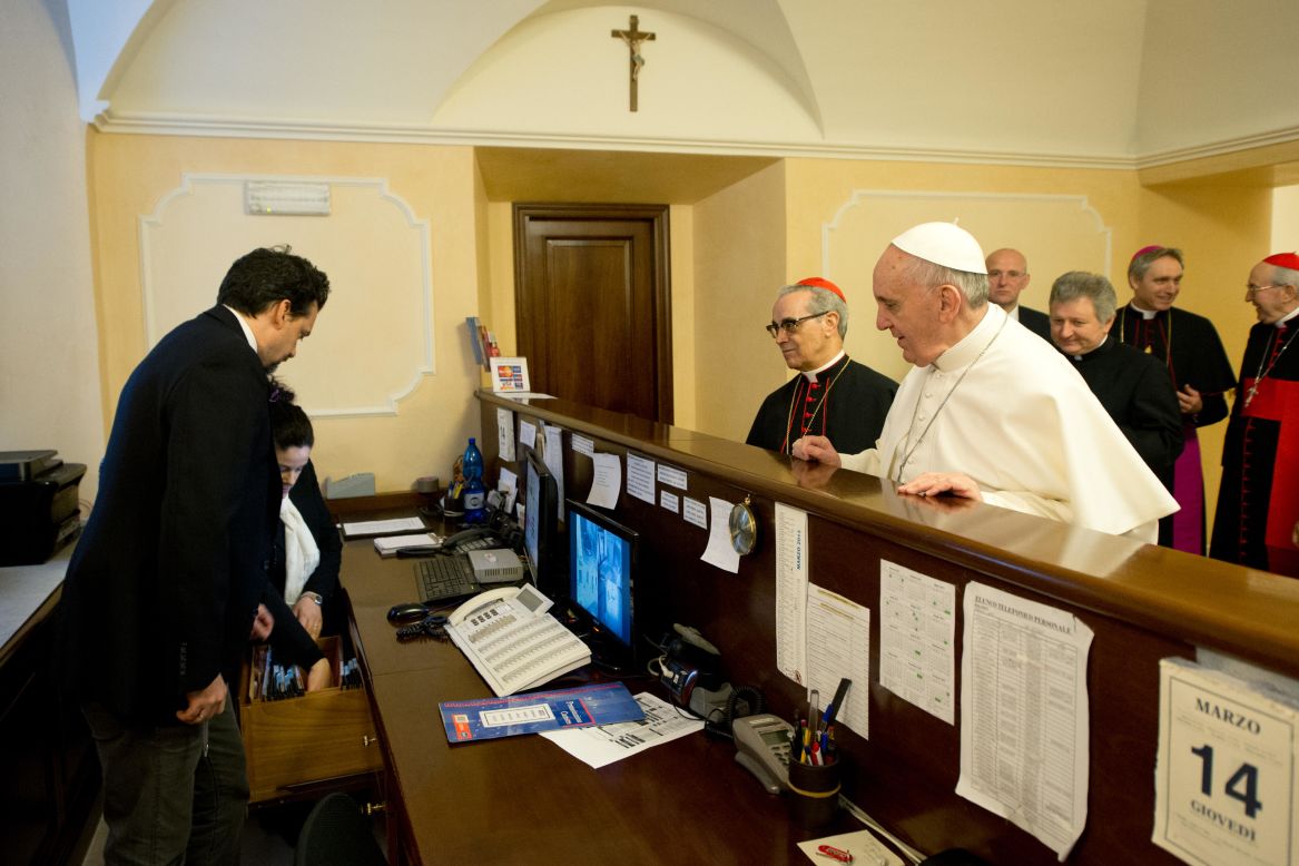 Francis stands at the reception desk of the Domus Internationalis Paulus VI residence on March 14, 2013, where he paid the bill for his stay during the conclave that would elect him leader of the world's 1.2 billion Catholics.