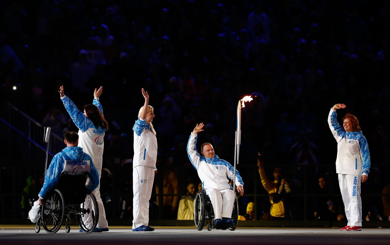 Paralympic torch bearers wave to the crowd.