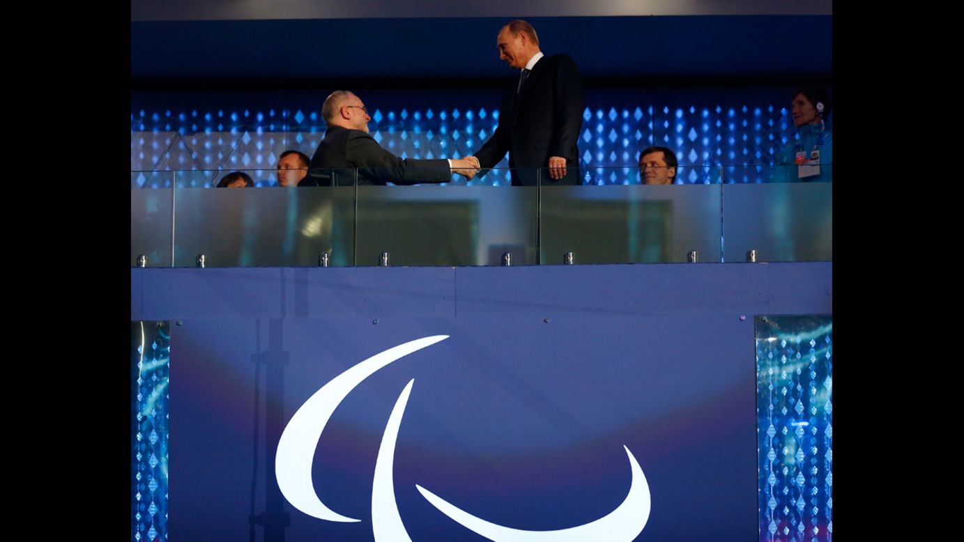 Sir Philip Craven, the president of the International Paralympic Committee, shakes hands with Russian President Vladimir Putin, right.