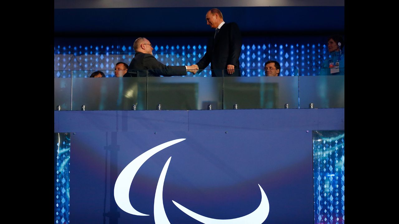 Sir Philip Craven, the president of the International Paralympic Committee, shakes hands with Russian President Vladimir Putin, right.
