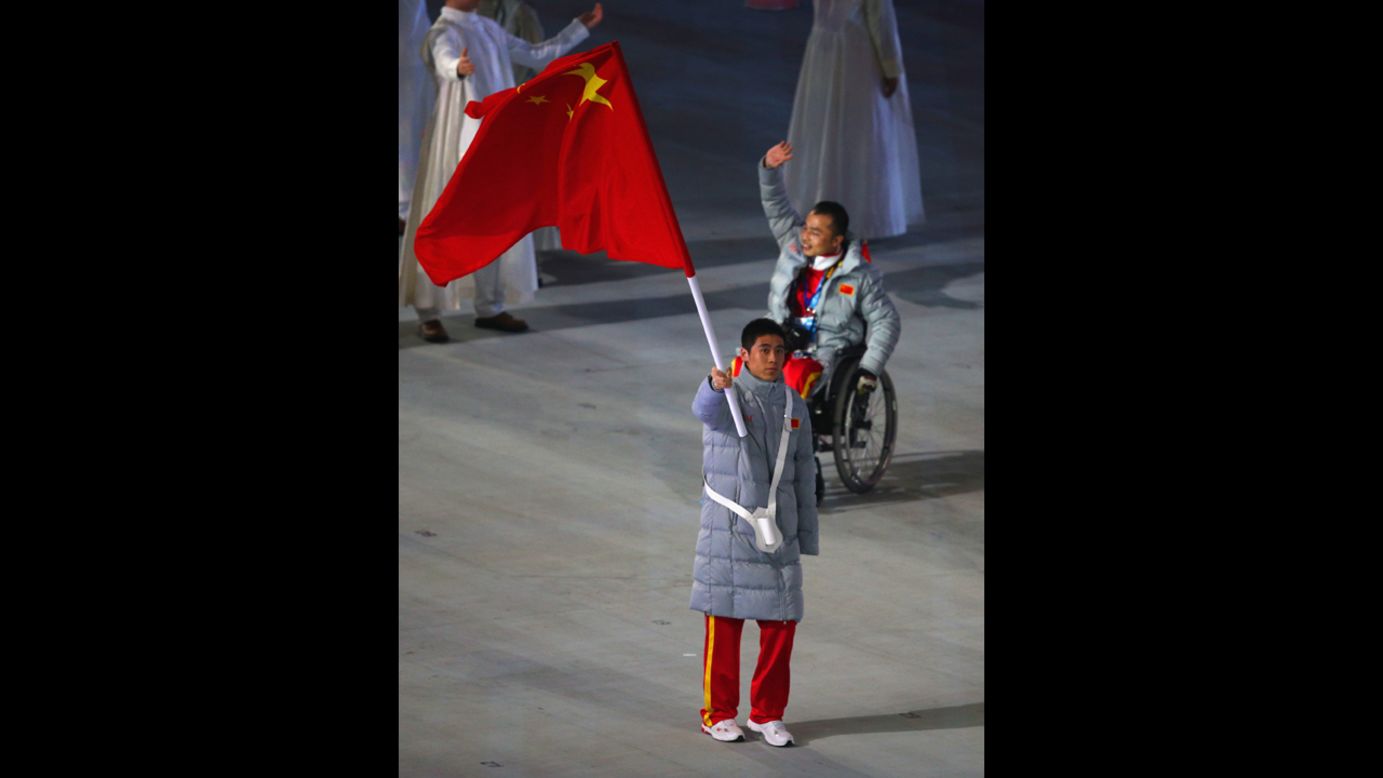 Chinese skier Ye Tian holds his country's flag.