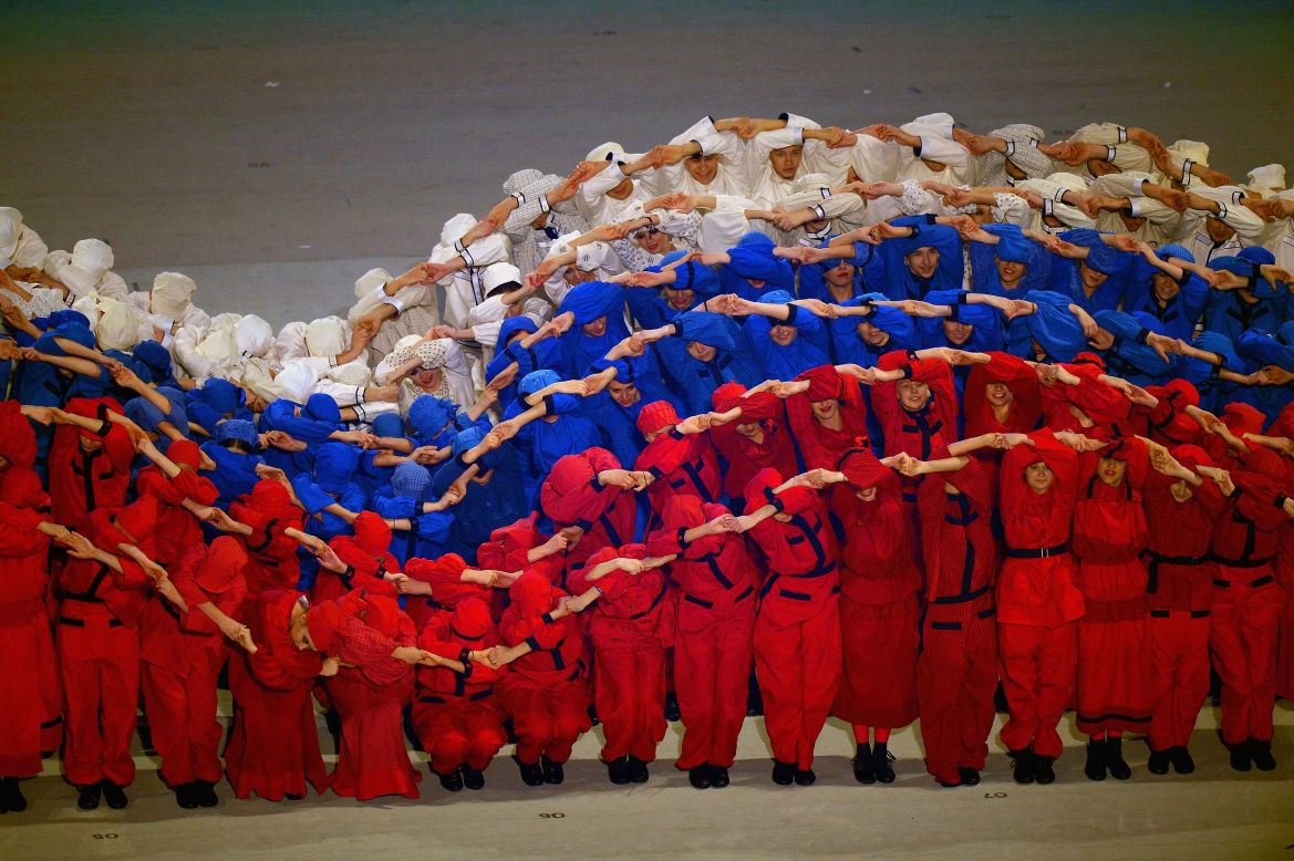 Performers simulate the Russian flag moving in the wind.