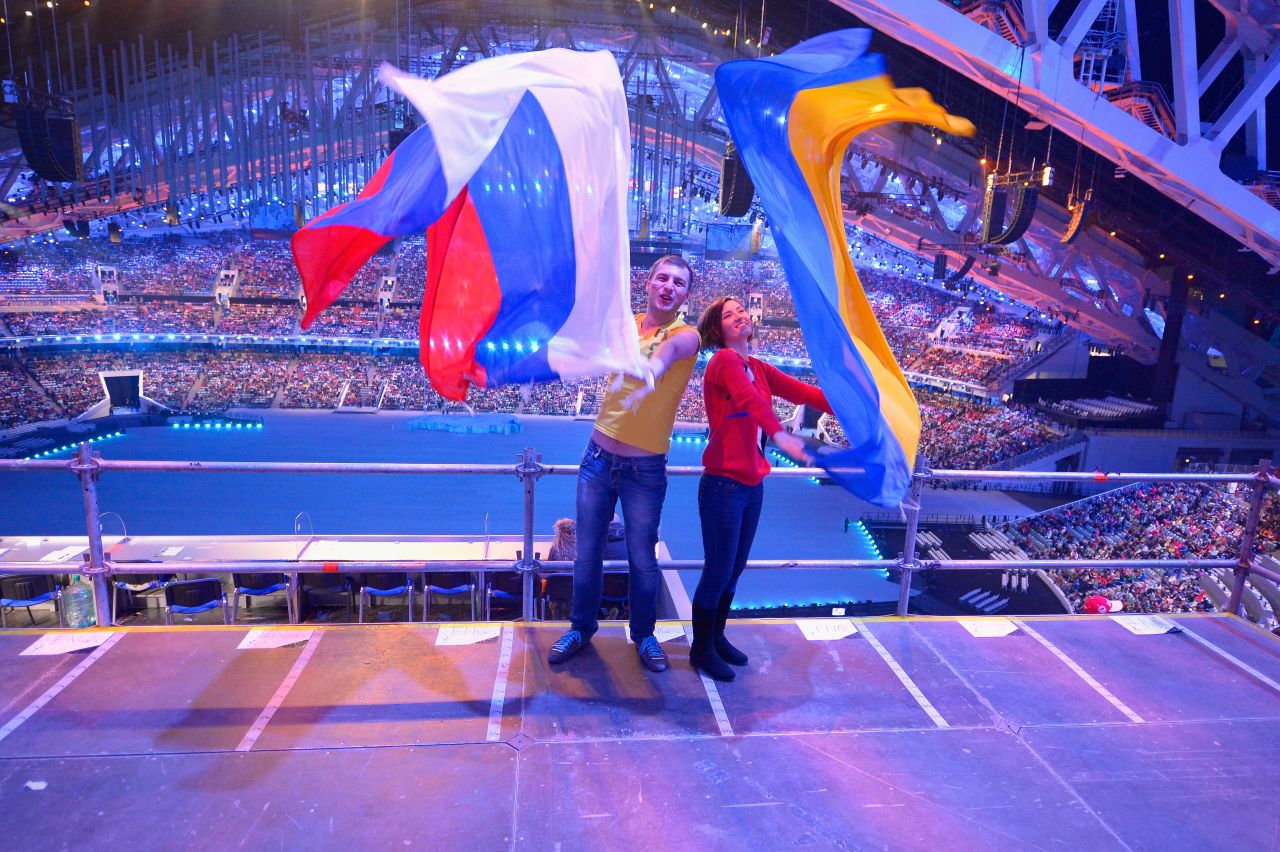 Two spectators pose with Russian and Ukrainian flags during the ceremony.