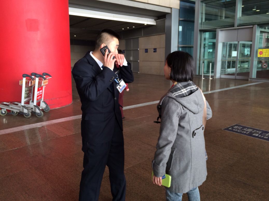 Una mujer habla a un miembro del personal en el aeropuerto de Beijing para obtener más información sobre el vuelo desaparecido.