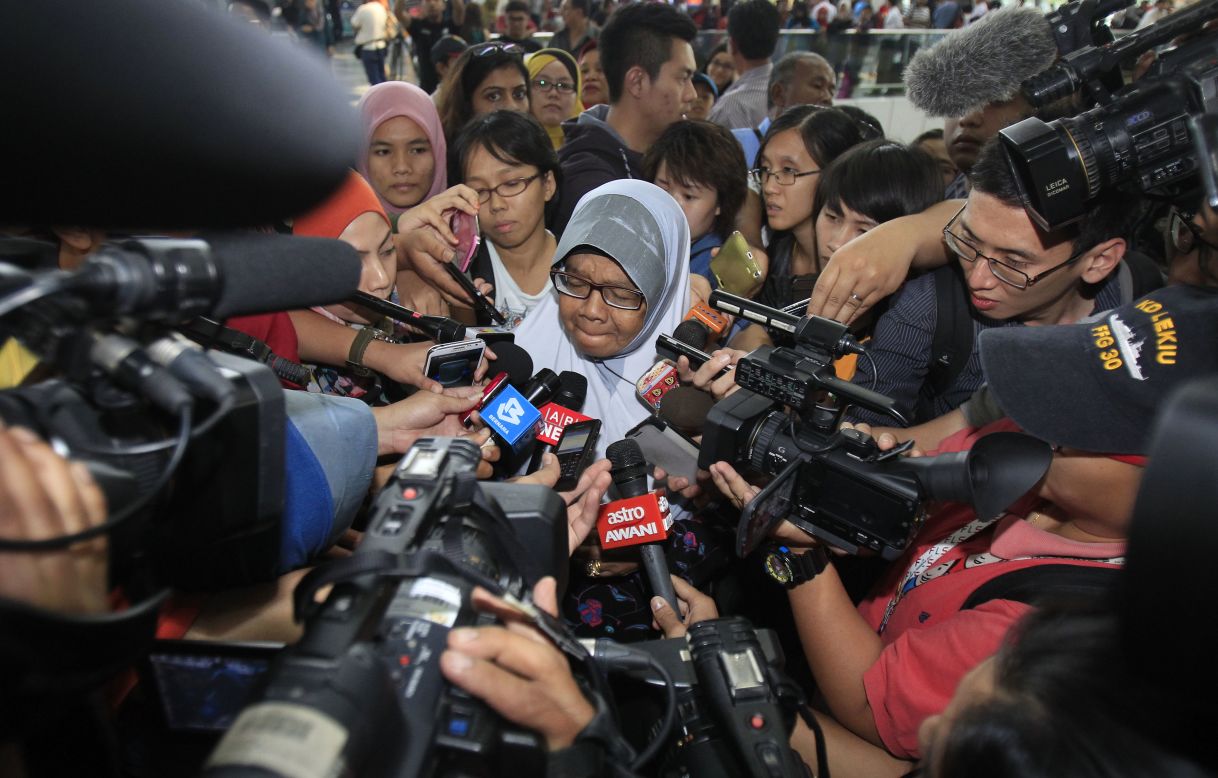 Una familiar de pasajeros a bordo de un avión de Malaysia Airlines es asediada por los periodistas en el aeropuerto internacional de Kuala Lumpur en Sepang, en las afueras de Kuala Lumpur, Malasia, el sábado 8 de marzo.