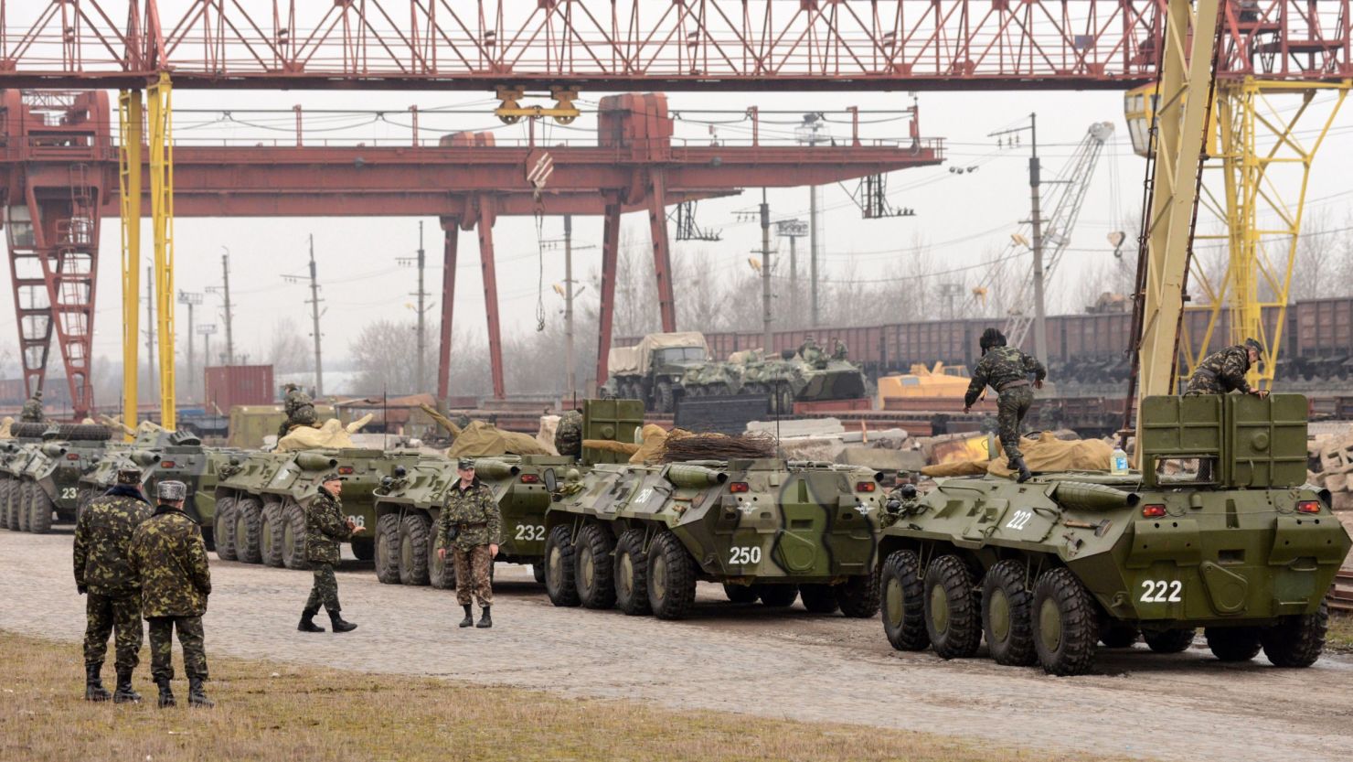 Ukrainian soldiers load armed personnel carriers into boxcars in the western Ukrainian city of Lviv on March 8.