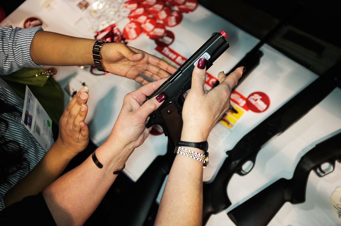 An attendee is given instructions on handgun use for a video game at a National Rifle Association exhibitor booth at CPAC.