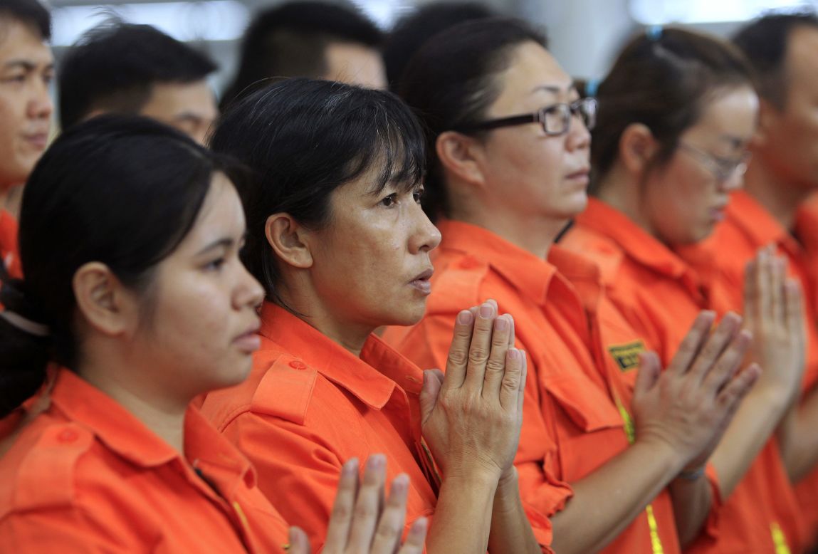 Los miembros del equipo de rescate de Fo Guang Shan oran el domingo 9 de marzo, en el aeropuerto internacional de Kuala Lumpur en Sepang, Malasia.