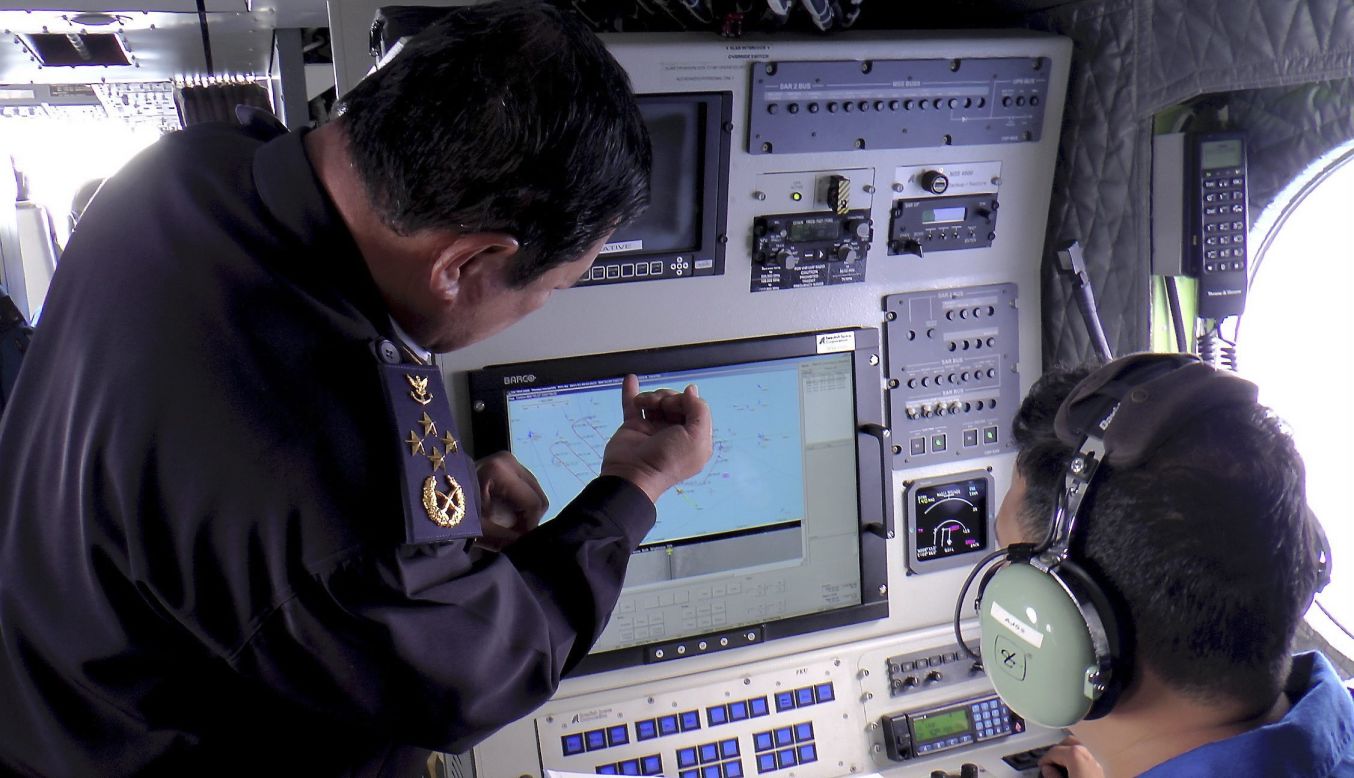Una imagen proporcionada por la Agencia de Control Marítimo de Malasia muestra al personal de la guardia costera de Malasia revisando una pantalla de radar durante la búsqueda y rescate de los desaparecidos del vuelo de Malaysia Airlines el 9 de marzo.